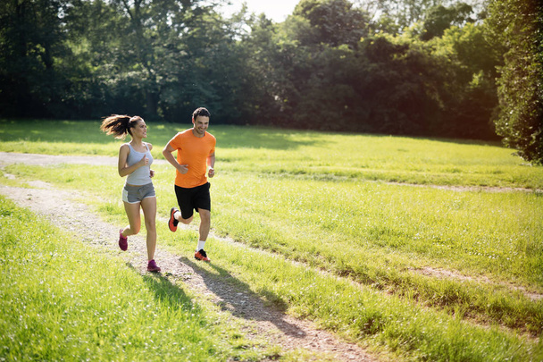 Healthy fit couple running in nature - Foto, afbeelding