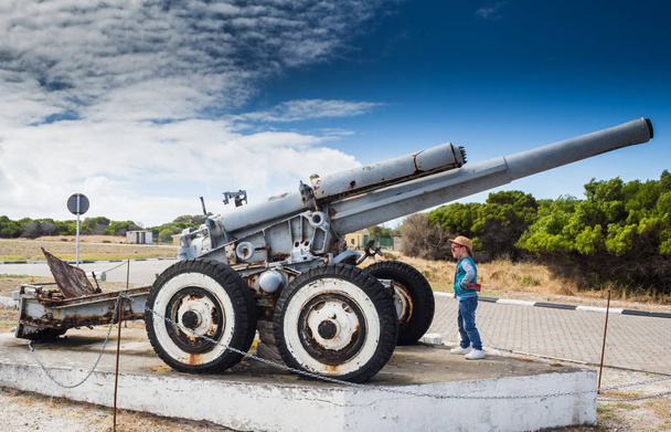 Menino olhando para a Segunda Guerra Mundial defesa costeira howitzer
 - Foto, Imagem
