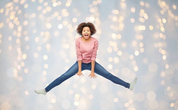 happy african american woman jumping over white - Fotografie, Obrázek
