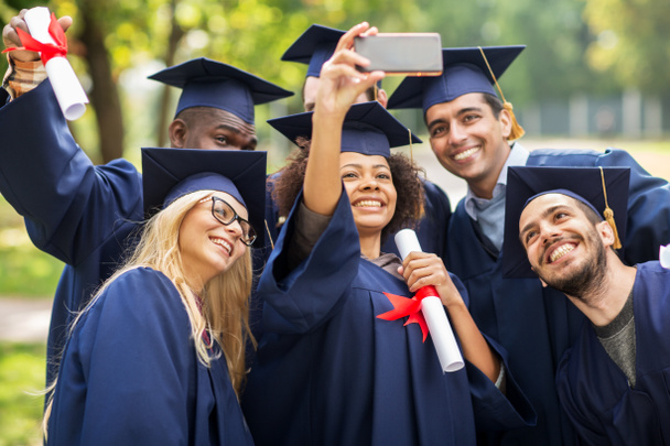 students or bachelors taking selfie by smartphone - Foto, imagen
