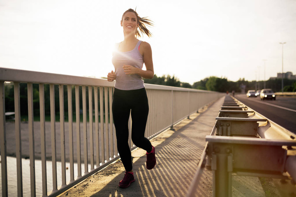 Sporty woman jogging outdoors - Fotoğraf, Görsel