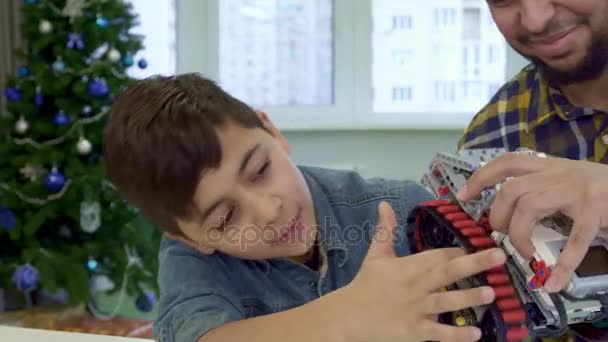 Boy puts his forefinger under the track of toy ATV - Video