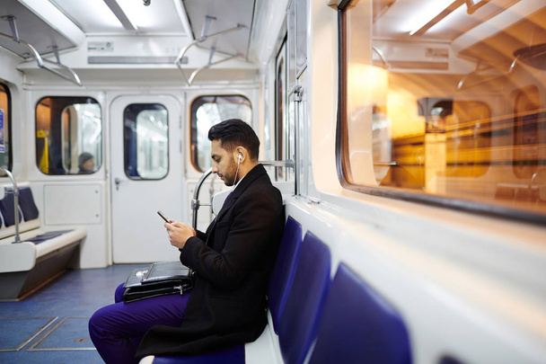 Biznesmen przy użyciu smartfona w metrze  - Zdjęcie, obraz