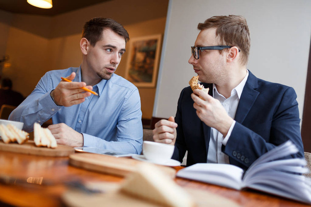  Nuoret miehet kommunikoivat kahvilassa
  - Valokuva, kuva