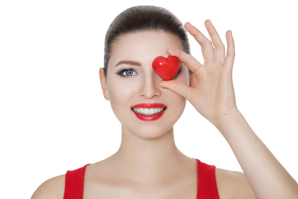 beautiful brunette woman holding red heart in front of the face. - Foto, Imagen