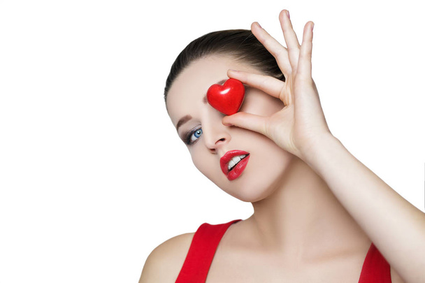 beautiful brunette woman holding red heart in front of the face. - Valokuva, kuva