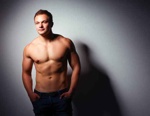 Healthy muscular young man. Isolated on black background - Zdjęcie, obraz