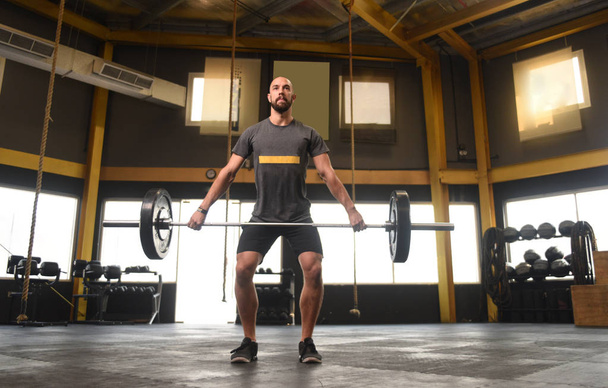 Strong man doing a crossfit power lift - Photo, Image