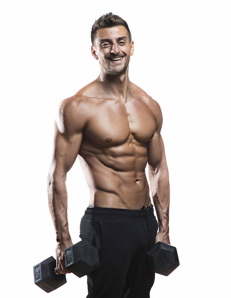 Muscular bodybuilder holding dumbbells  - Fotó, kép