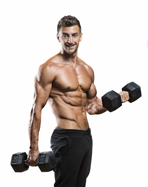Gespierde bodybuilder holding halters gewichten - Foto, afbeelding