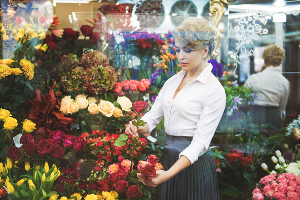 Calm woman making bouquet in shop - Fotoğraf, Görsel