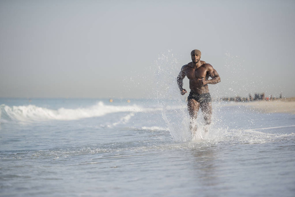 hombre corriendo en el borde de la playa
 - Foto, Imagen