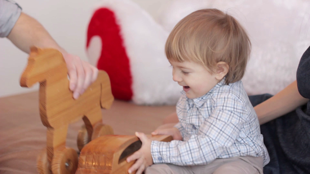 parents with a child playing on bed with toys - Filmagem, Vídeo