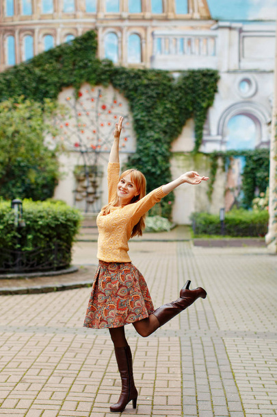 Red-haired girl in a skirt walks and rejoices in the city on a s - Fotografie, Obrázek