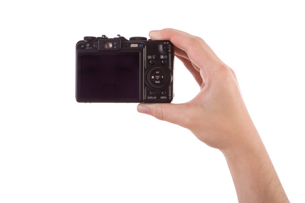 el üzerinde beyaz izole bir dijital kamera ile fotoğraf çekimi - Fotoğraf, Görsel