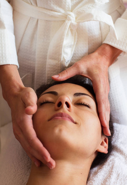 Face Massage. Close-up of a beautiful Woman Getting Spa Treatmen - Photo, image