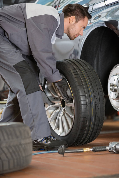 mechanic fixing car's tire  - Foto, Imagen