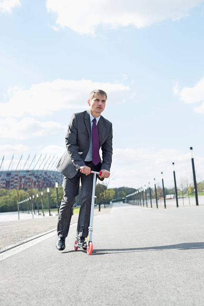Businessman riding scooter - Valokuva, kuva