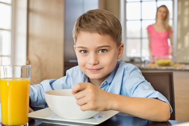 Boy having breakfast at table - Фото, изображение