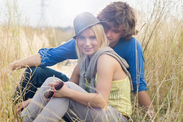 woman sitting with loving man in field - Foto, Imagen