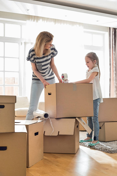 Mother and daughter packing boxes - 写真・画像