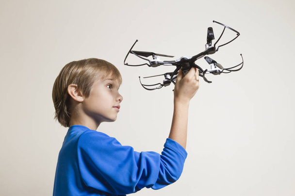 Pequeño niño sosteniendo el dron, preparándose para despegar
 - Foto, Imagen