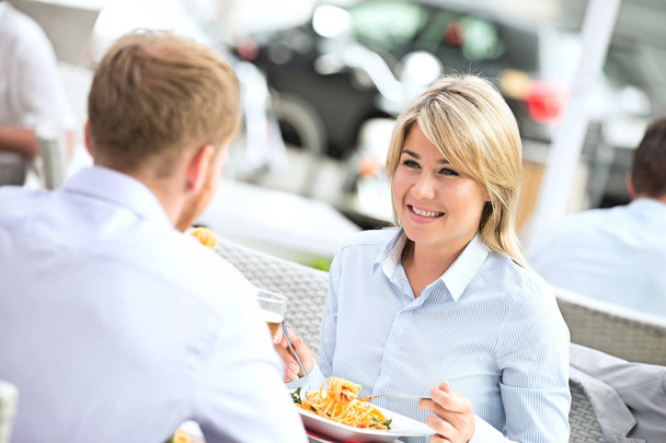 businesswoman having food with male colleague - Foto, Bild
