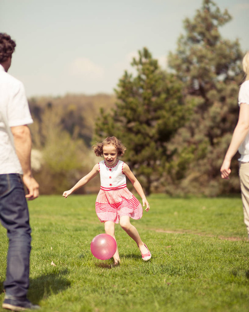 Daughter kicking ball to father - Photo, image