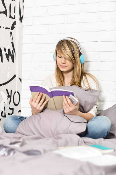 Girl reading book in bedroom - Fotografie, Obrázek
