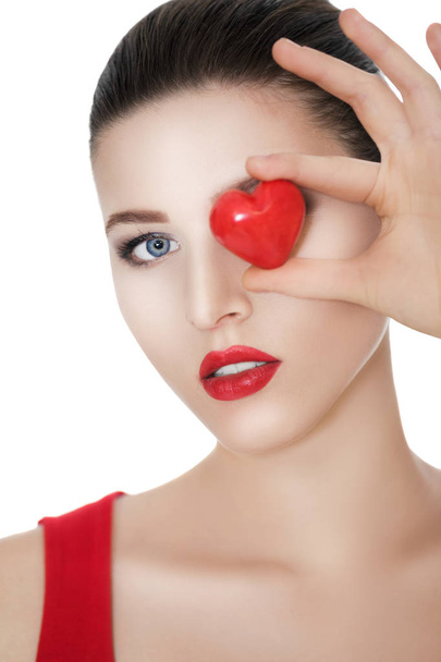 beautiful brunette woman holding red heart in front of the face. - Fotó, kép