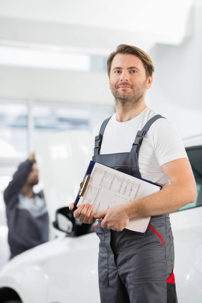 automobile mechanic with clipboard  - Foto, afbeelding