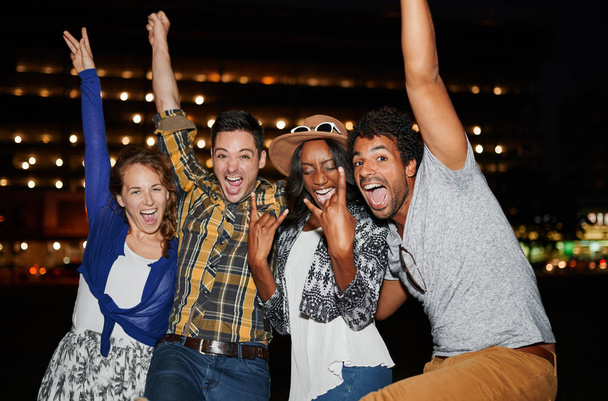 Grupo multi-étnico milenar de amigos posando para uma foto usando flash ao ar livre à noite
 - Foto, Imagem