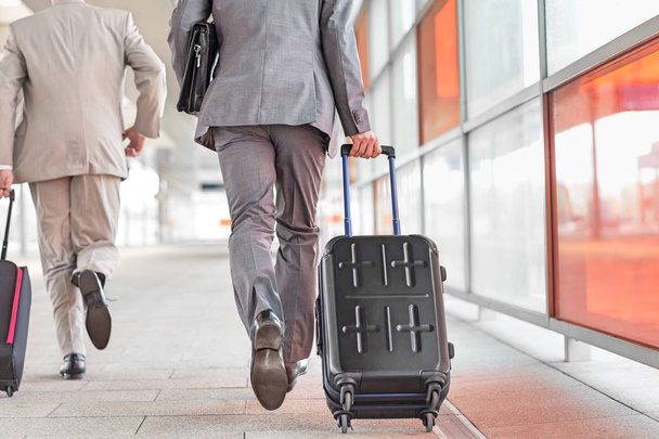 Businessmen with luggage running  - 写真・画像