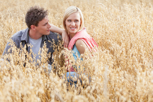 couple relaxing amidst field - Foto, Imagem