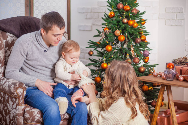 Happy family in jeans sitting xmas tree anticipation new year - Foto, imagen