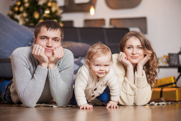 Happy family is lying on carpet tree and smiling - Fotografie, Obrázek