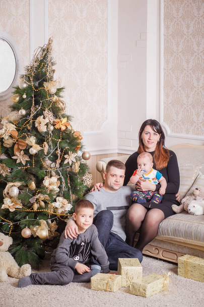 family sitting near Christmas Tree - Foto, afbeelding