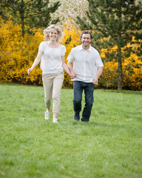 Couple running through park - Foto, immagini