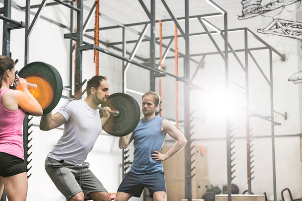 man in lifting barbell at crossfit gym - Zdjęcie, obraz