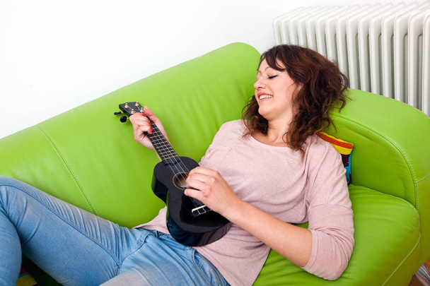 Young woman playing ukulele - 写真・画像