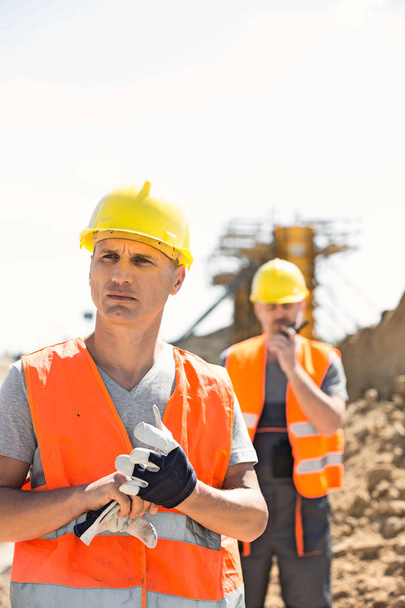 Male workers standing at construction site  - Fotó, kép