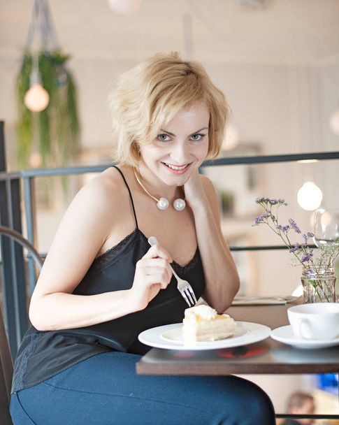 Happy young woman eating cake - Zdjęcie, obraz