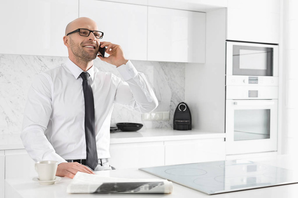 Businessman on call at kitchen - Foto, Imagen