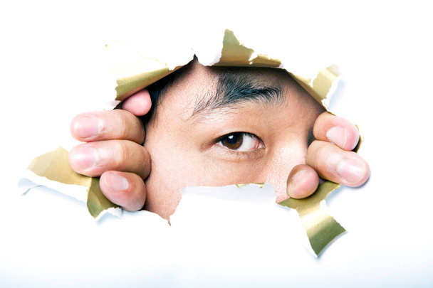 man looking through paper hole - Foto, Imagen