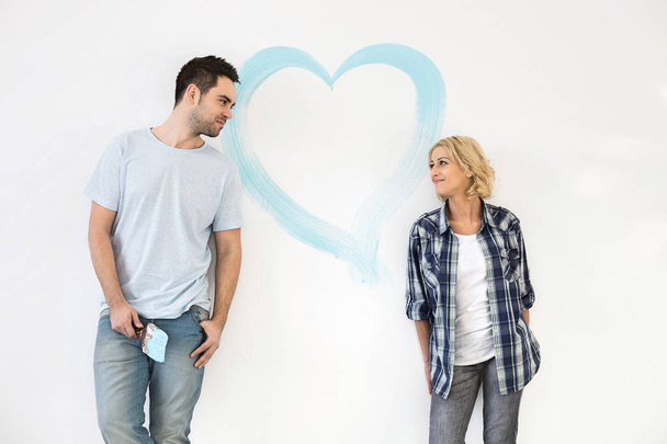Couple with painted heart on wall - Φωτογραφία, εικόνα
