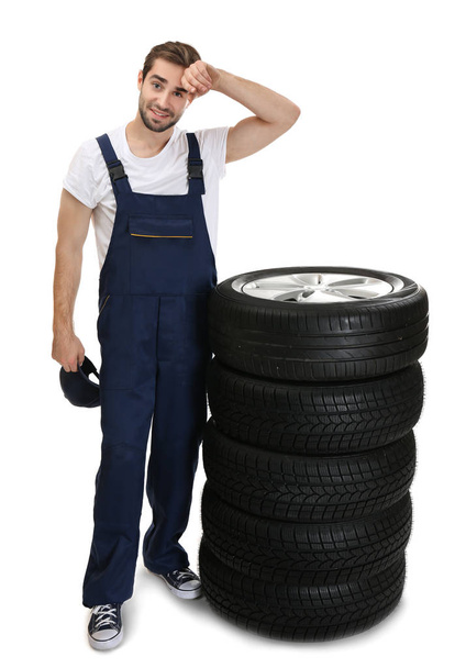 Young mechanic with wheels  - Фото, зображення