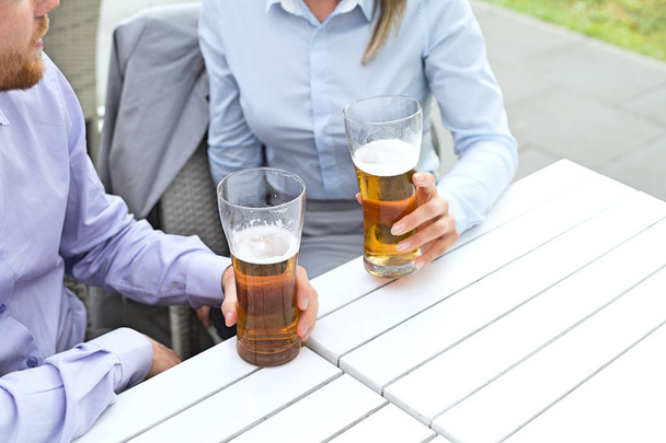 casal de negócios segurando copos de cerveja
 - Foto, Imagem