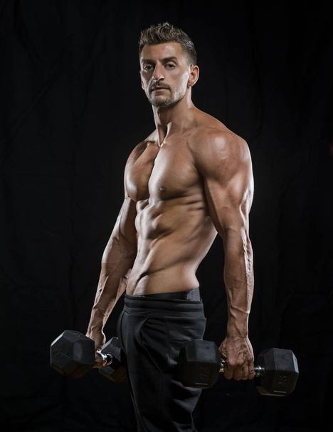 Muscular bodybuilder holding dumbbells  - Photo, Image