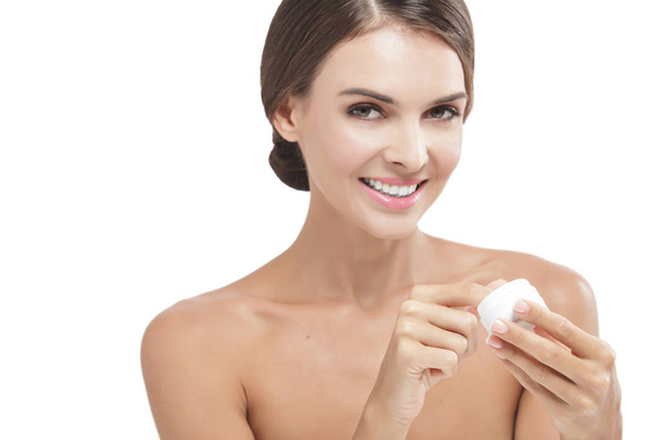 beautiful woman smiling while taking some facial cream - Foto, Imagem