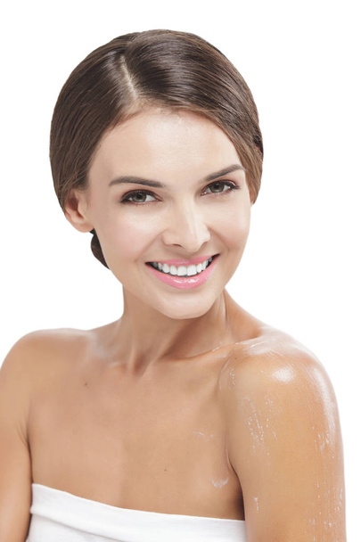 beautiful woman smiling with some body lotion on her arms - Фото, зображення